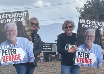 Two volunteers are holding Peter George corflutes. The corflutes read: Independent for Franklin Vote 1 Peter George.